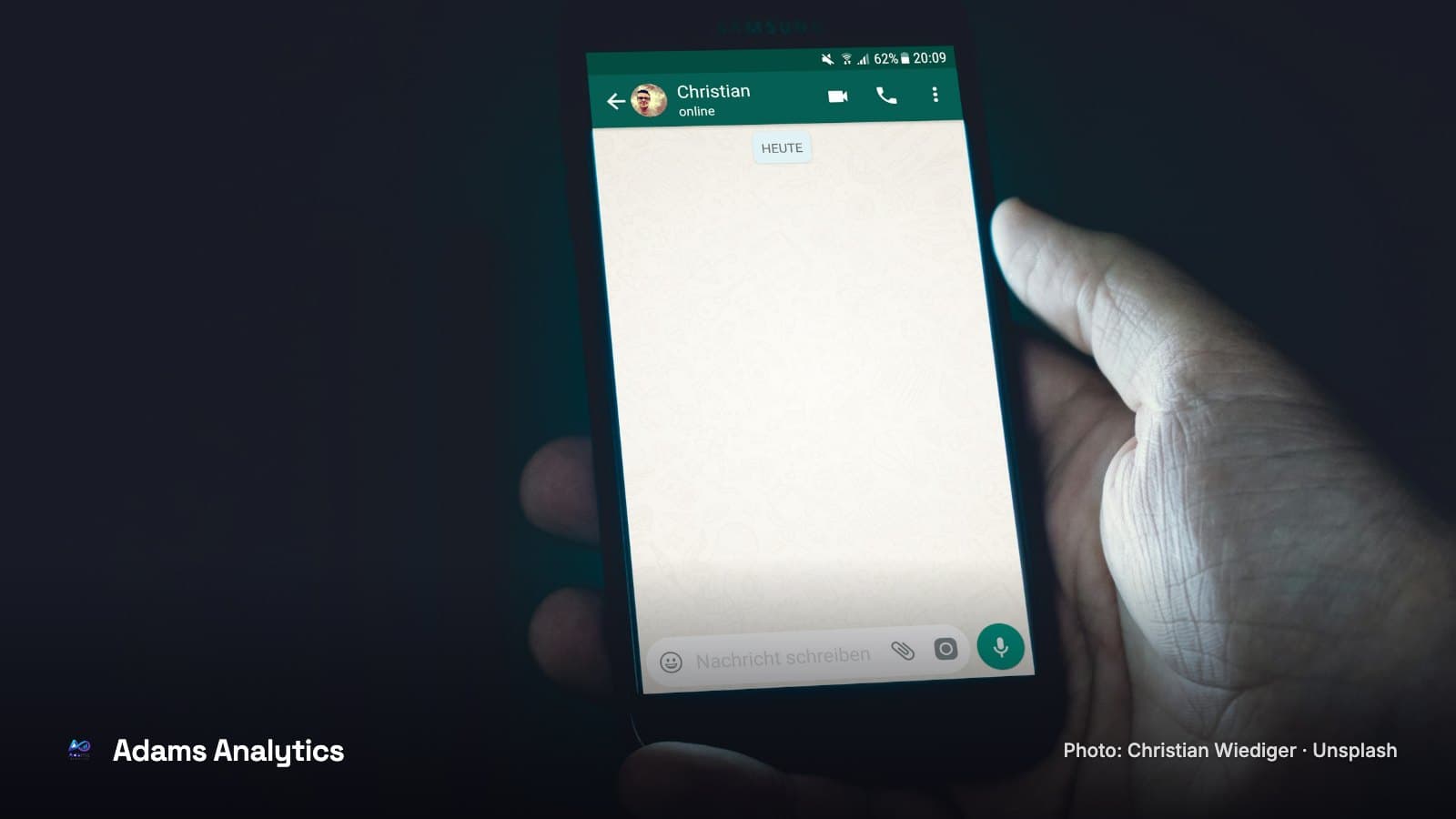 A hand holding a smartphone with a chat conversation on the screen