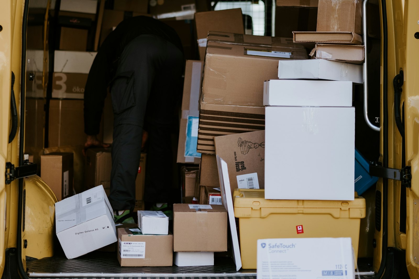 Cardboard boxes stacked in the back of a delivery van