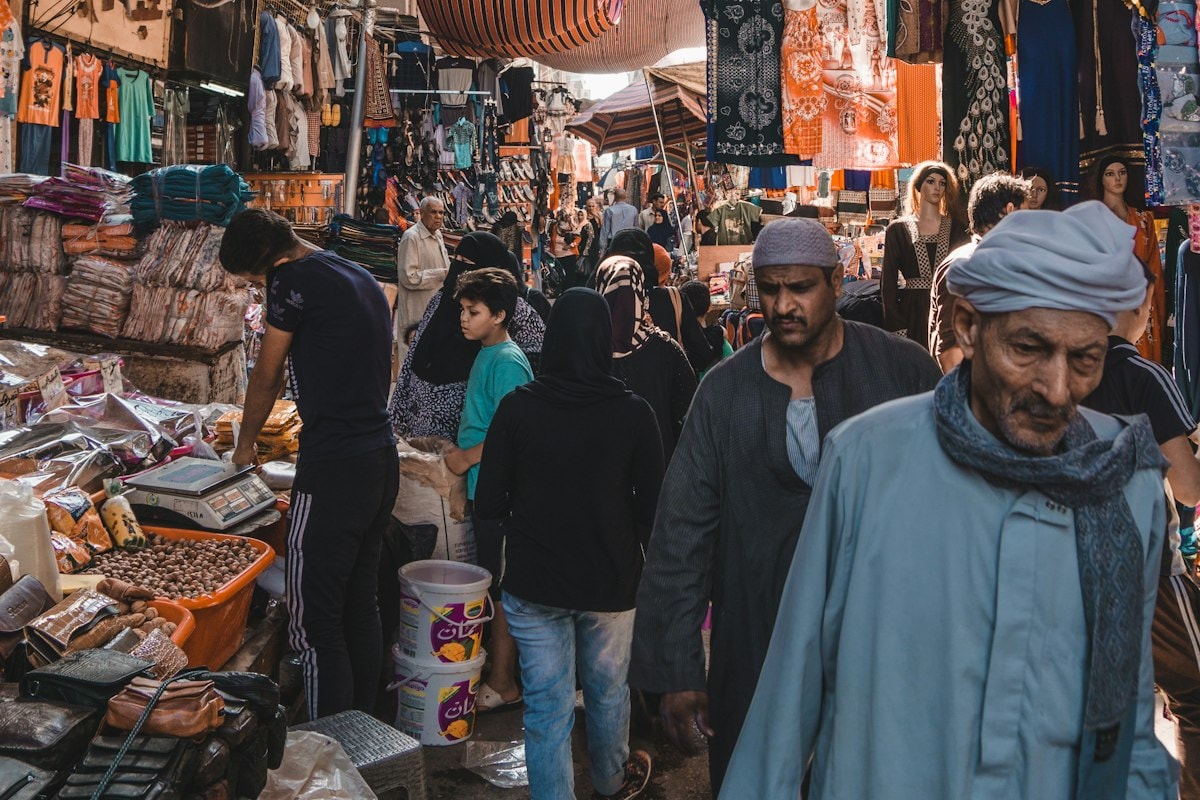 A crowded market street in Cairo lined with shops and stalls