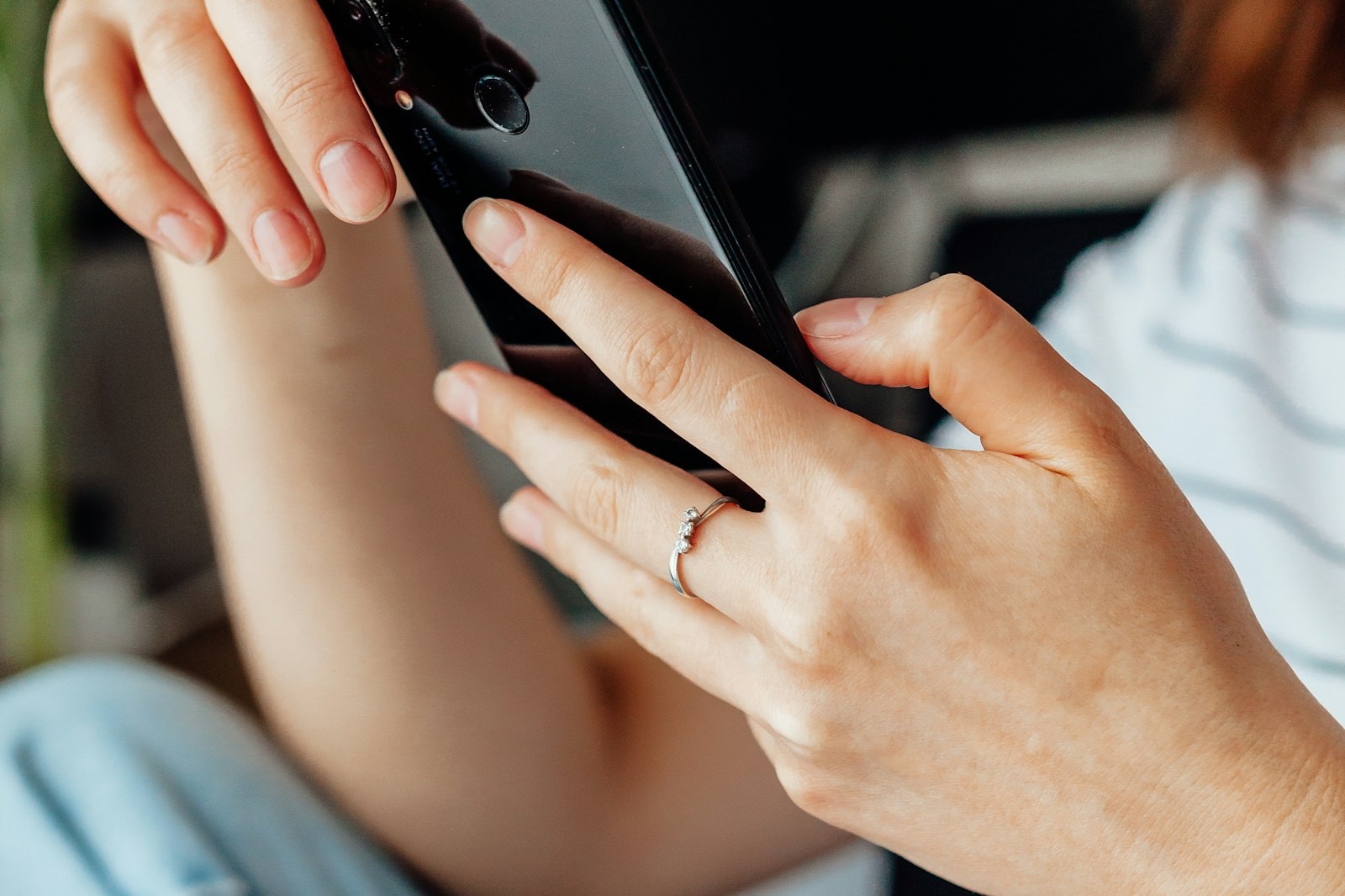 A person holding a phone and typing a message