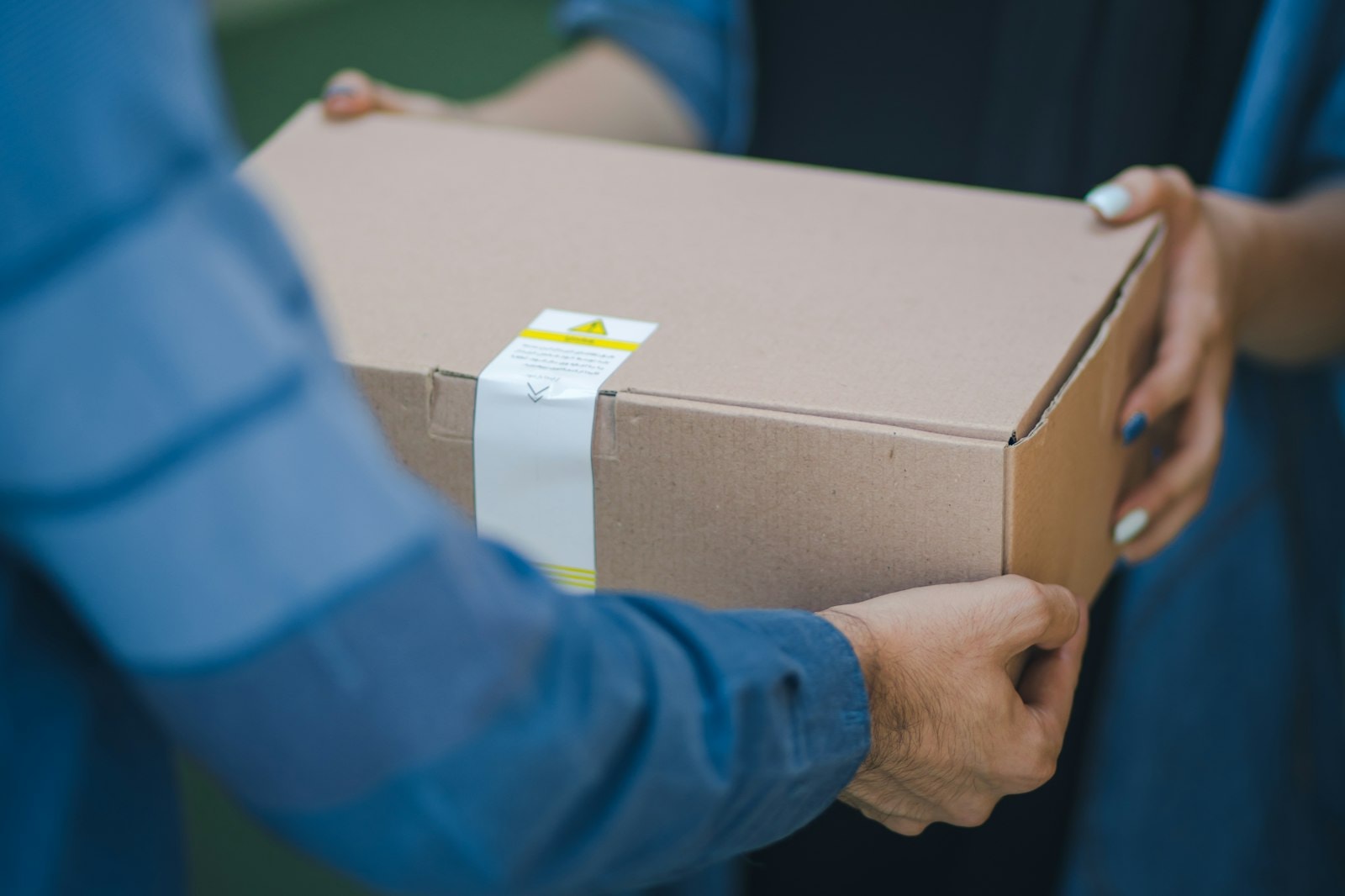 Hands passing a cardboard box to a customer
