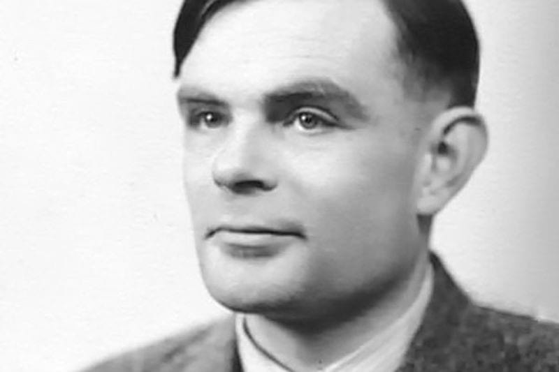 Black and white portrait of Alan Turing in a suit and tie