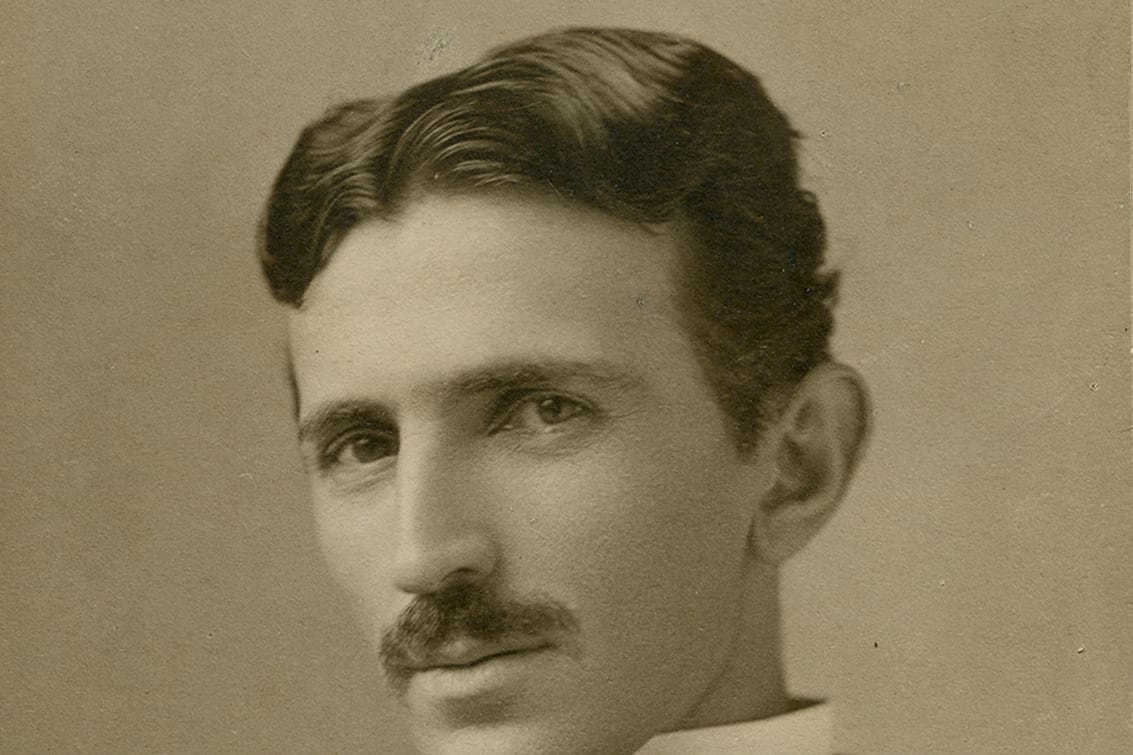 Sepia portrait of Nikola Tesla with a moustache, in a suit