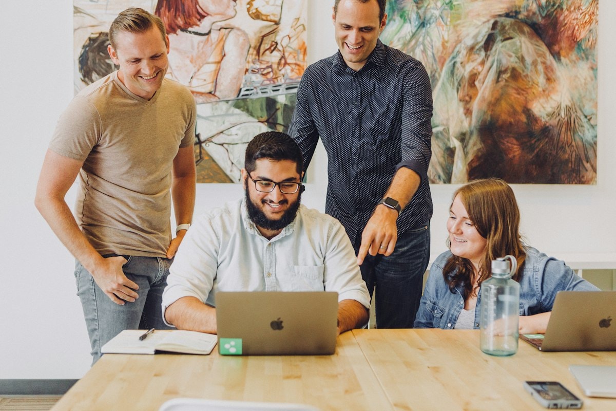 A team working together around a laptop in a bright office