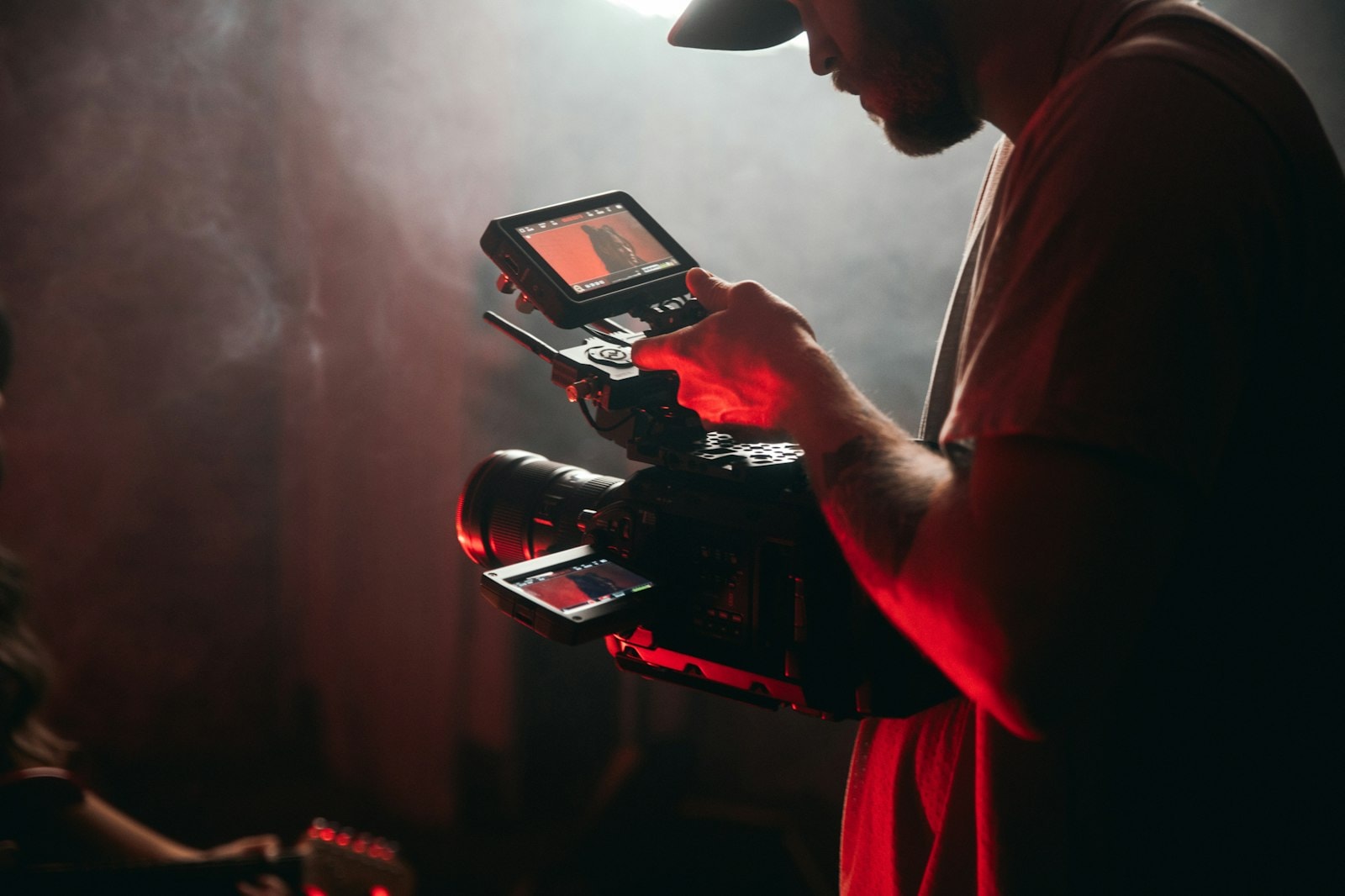 A videographer checking a shot on a camera screen