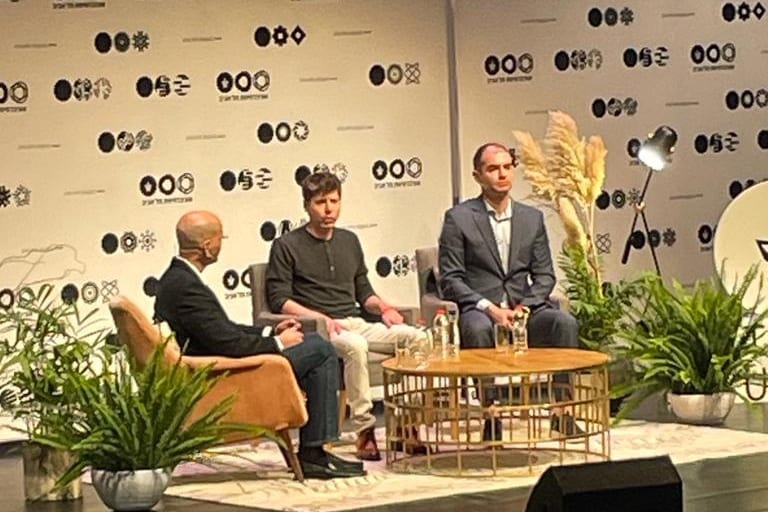Sam Altman and Ilya Sutskever seated on a stage with a host at Tel Aviv University